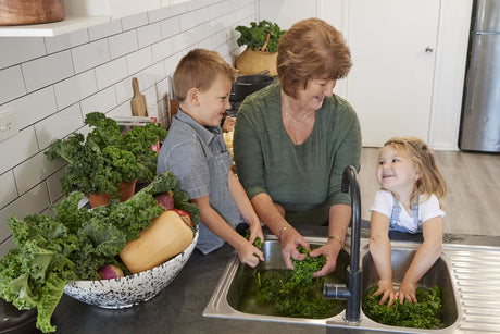 The Glavocich family washing fresh produce in the kitchen